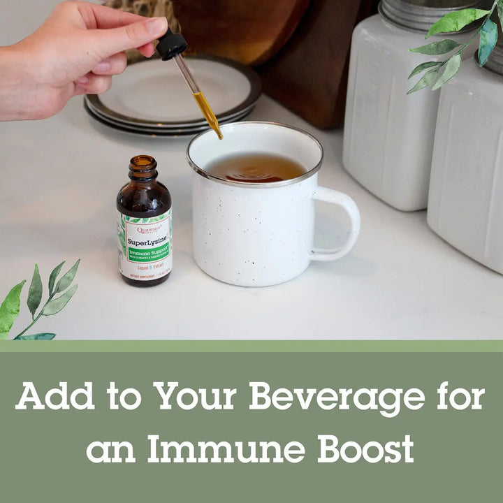 Hand using a dropper to add liquid from a bottle into a mug of tea on a kitchen counter.